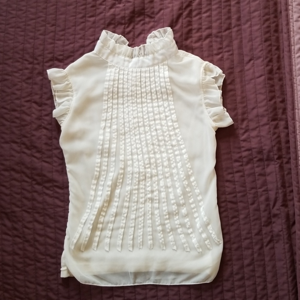 Blouse, ruffles around neck line and sleeves.